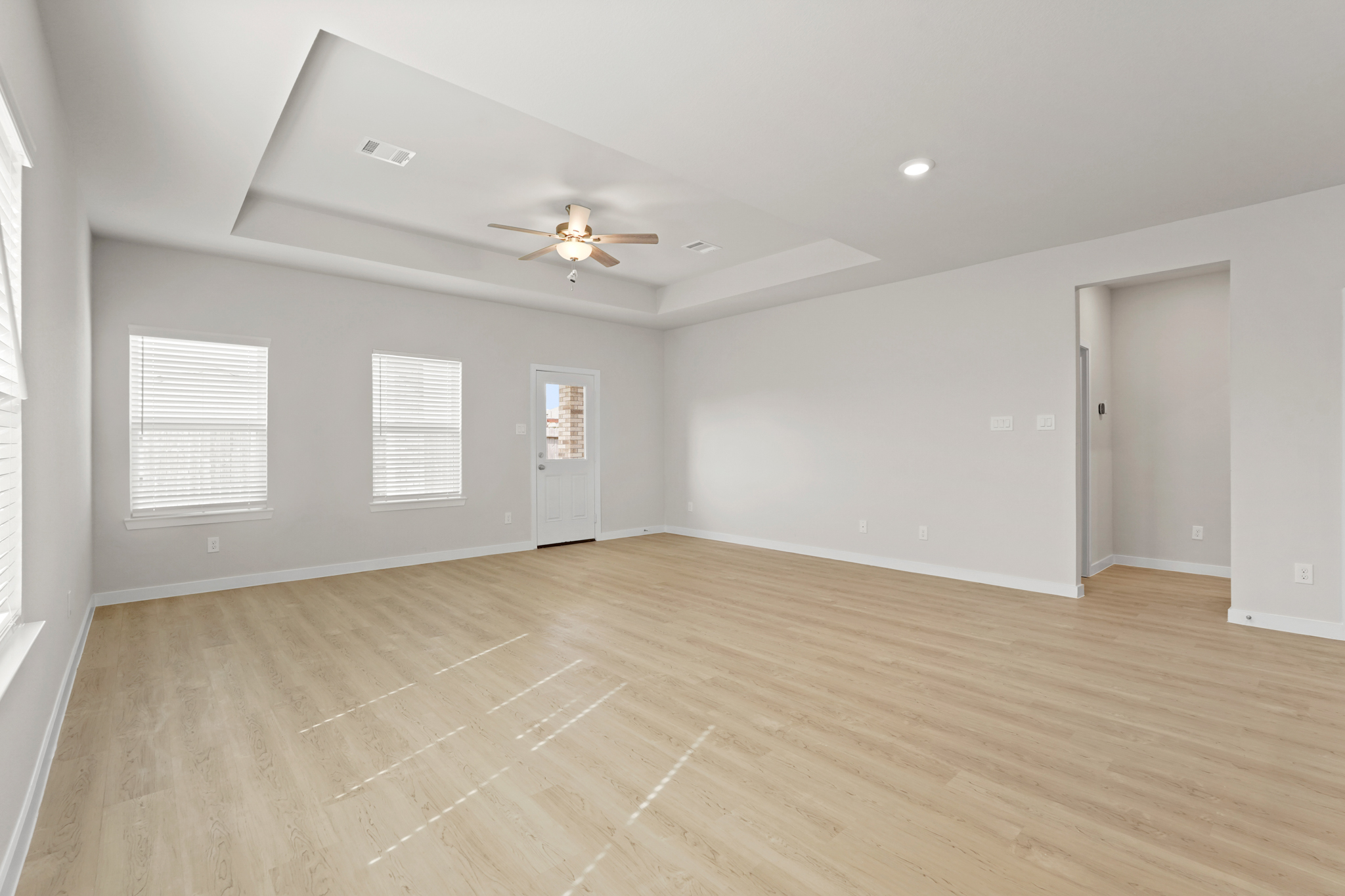 A room with a wood floor and a ceiling fan.