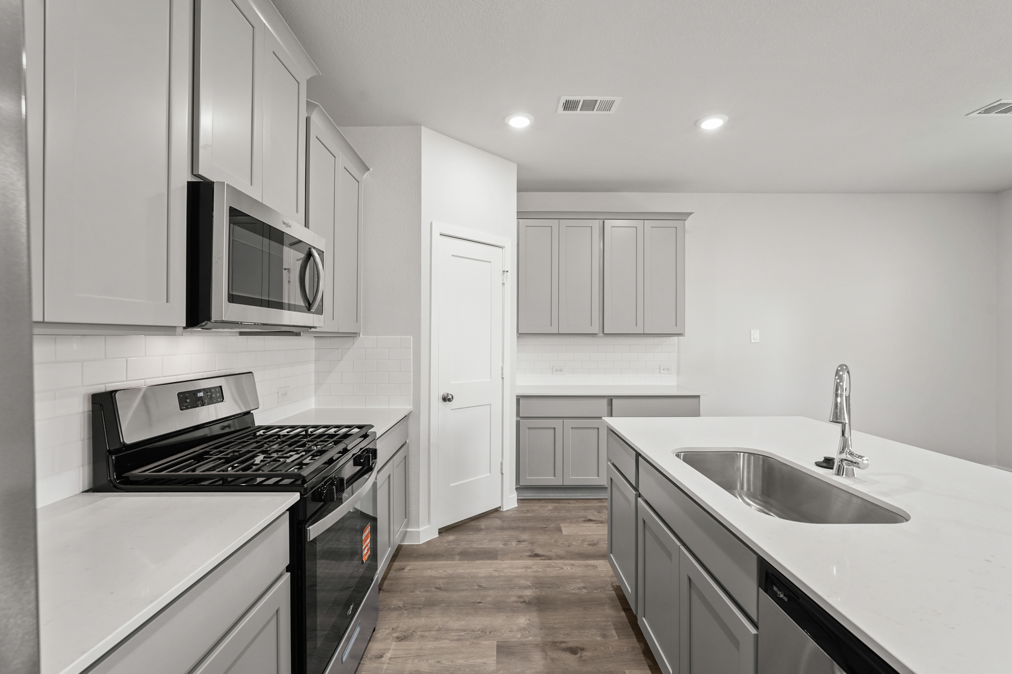 A kitchen with white cabinets.