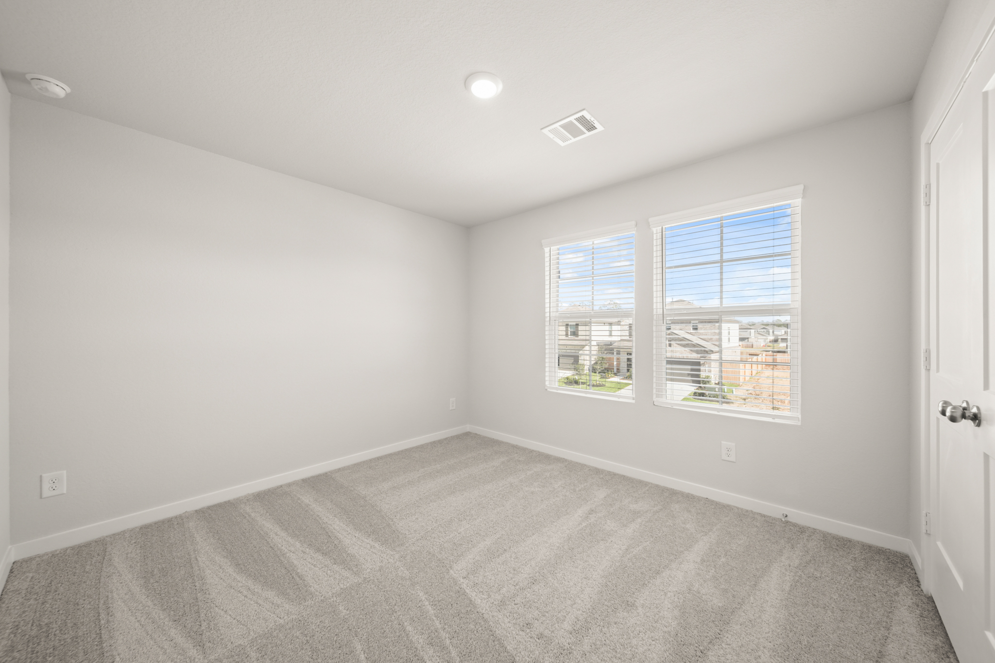 A room with a window and a carpet.