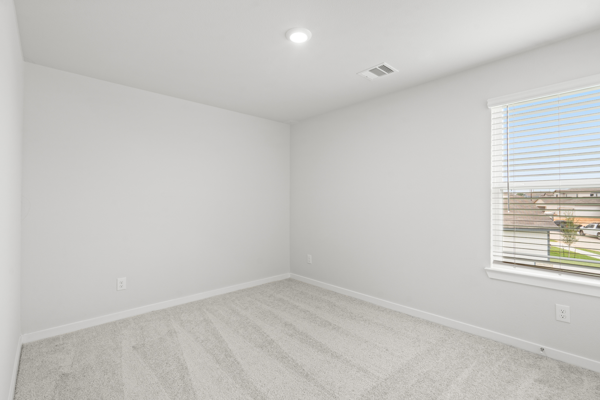 A room with a window and a carpet.