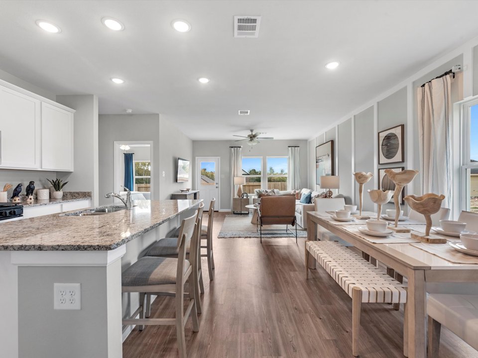 A kitchen with a dining table and chairs.