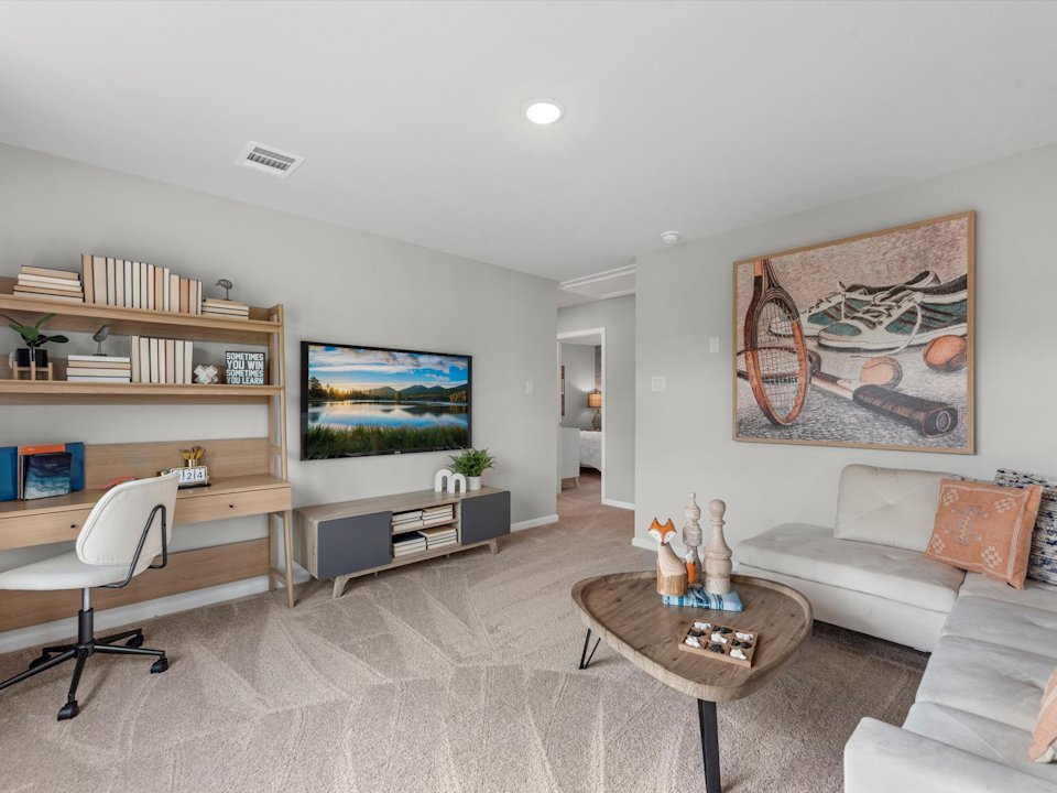 A living room with a desk and a couch.