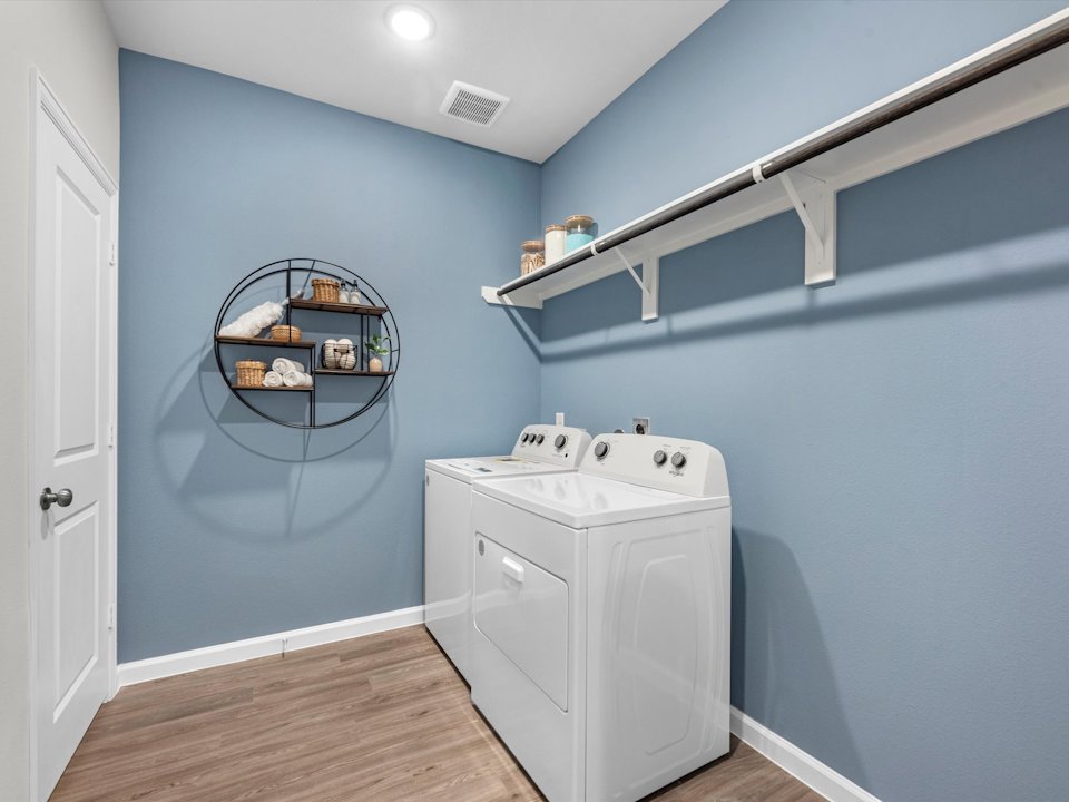A laundry room with a white shelf.