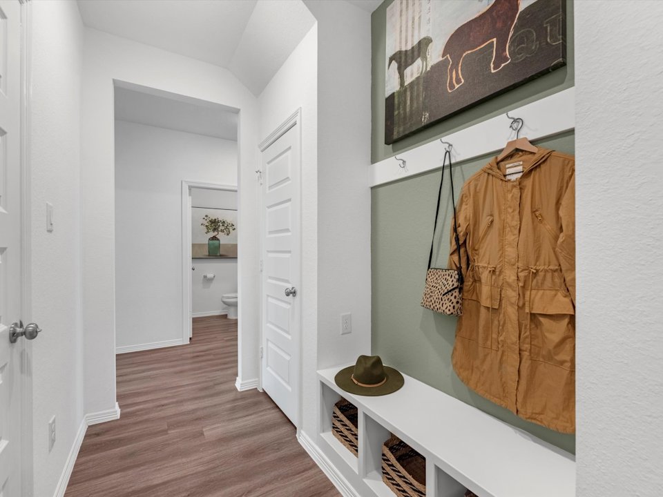 A bathroom with a hat and a coat rack.