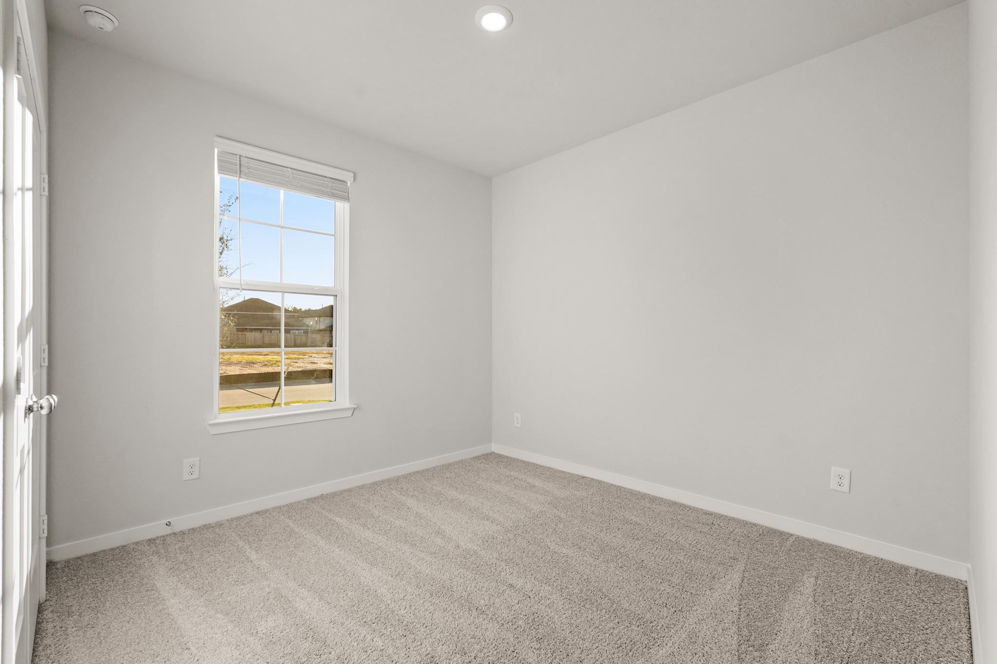 A room with a window and carpet.