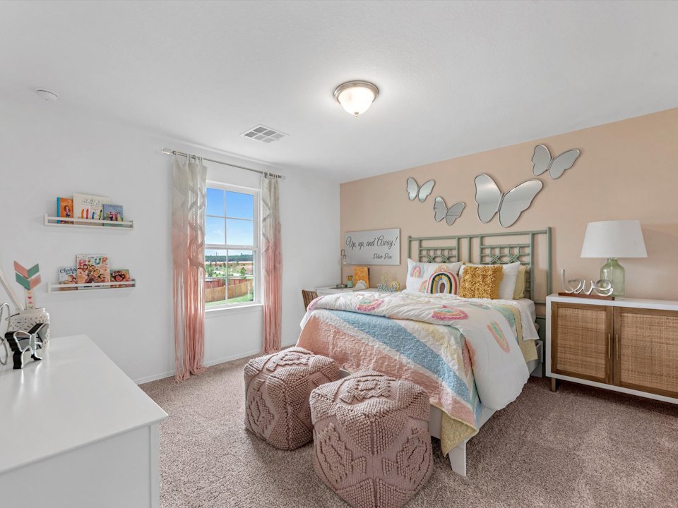 A bedroom with a bed and a chair.