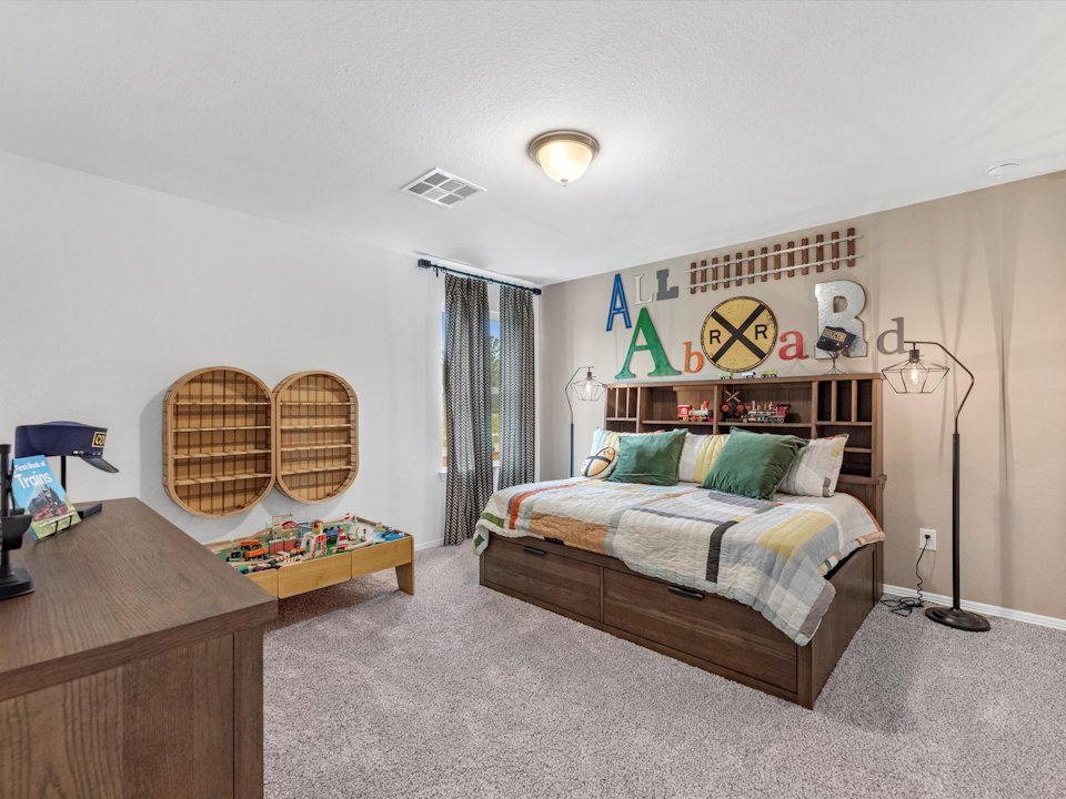 A bedroom with a bed and desk.