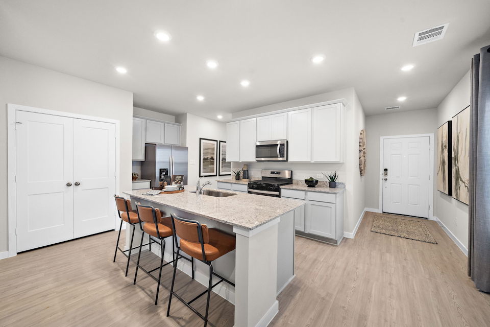 A kitchen with white cabinets.