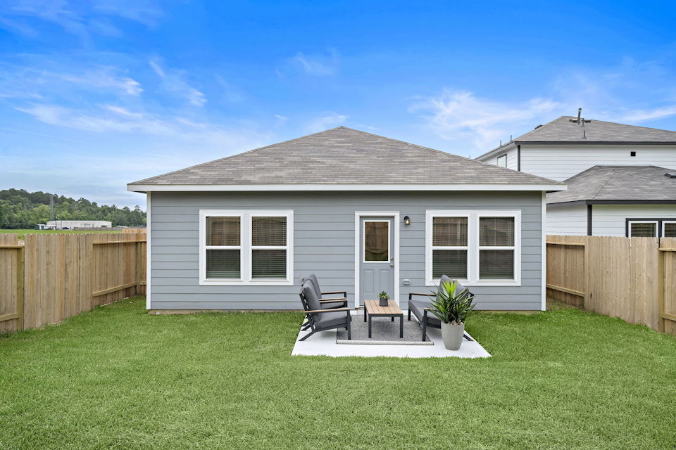 A house with a patio and a table and chairs in the front.