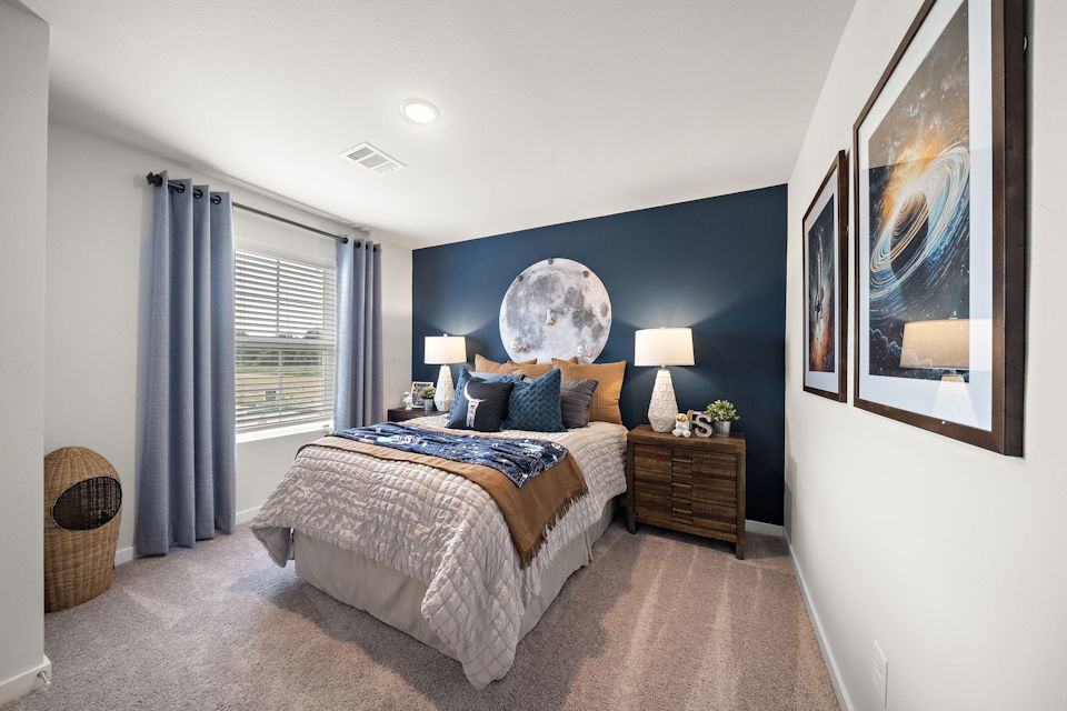 A bedroom with a bed and a lamp.