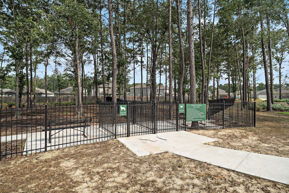 A fenced off area with trees in the back.