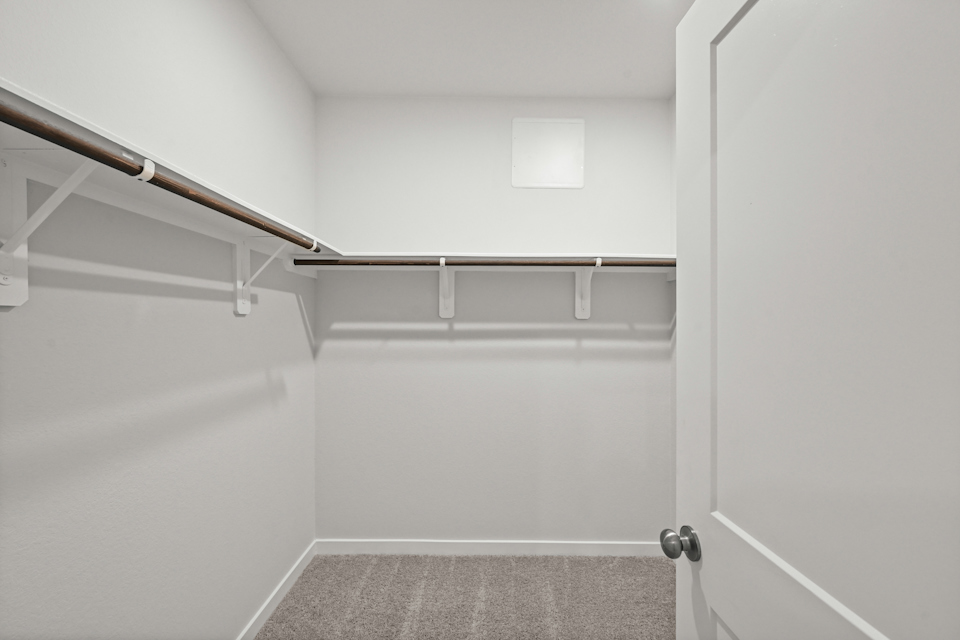 A white bathroom with a metal bar.