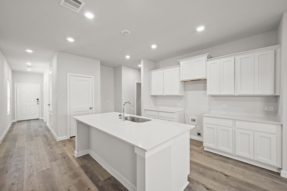 A kitchen with white cabinets.