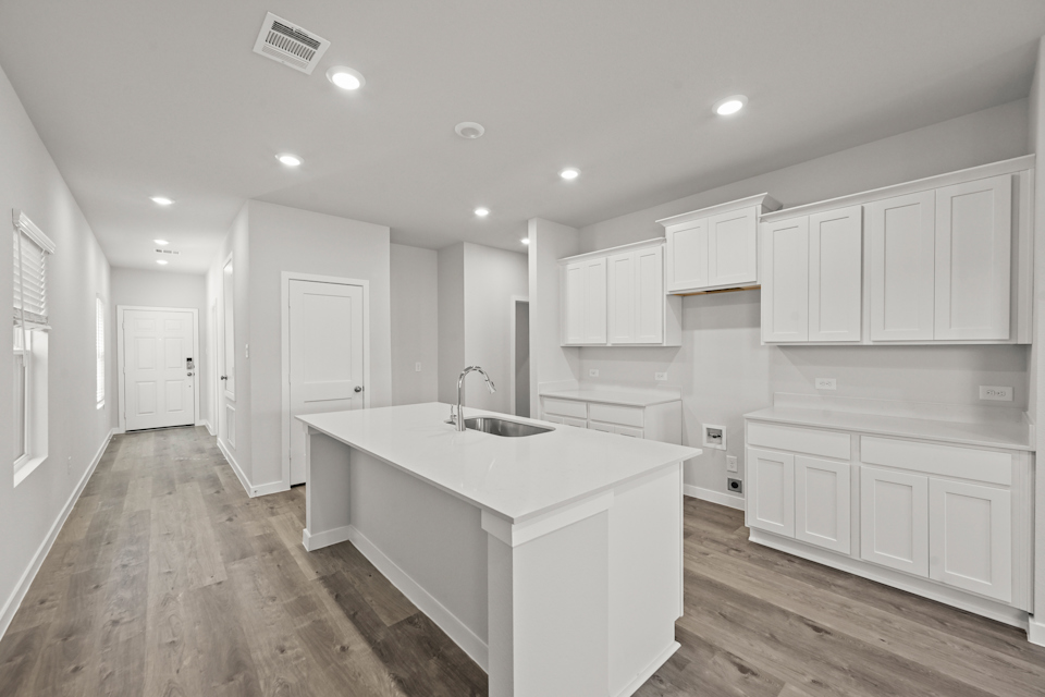 A kitchen with white cabinets.