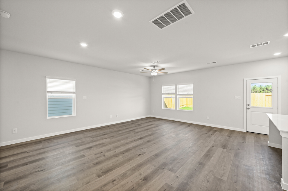 A room with a wood floor and windows.