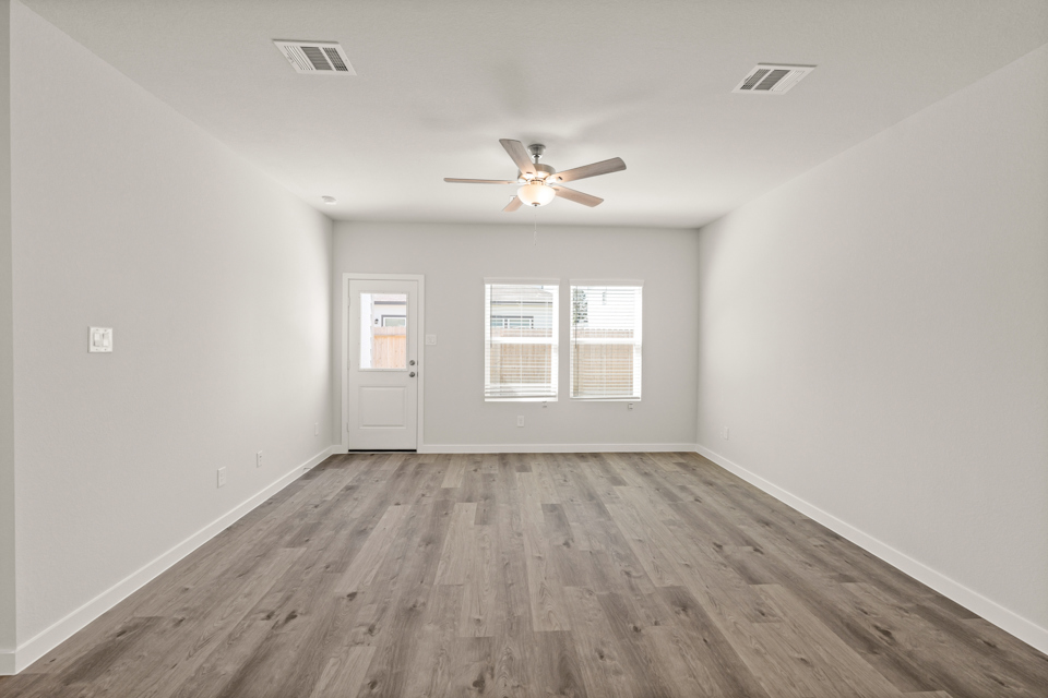 A room with a wood floor and a ceiling fan.