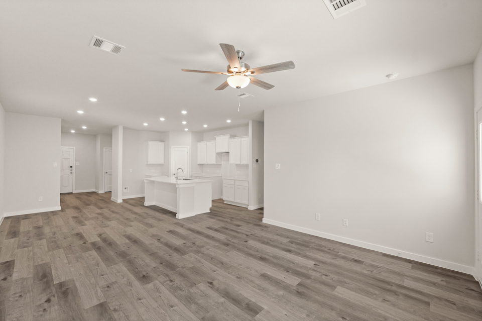 A room with a wood floor and a ceiling fan.