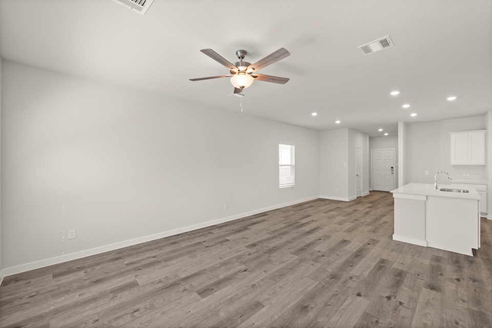 A room with a wood floor and a ceiling fan.