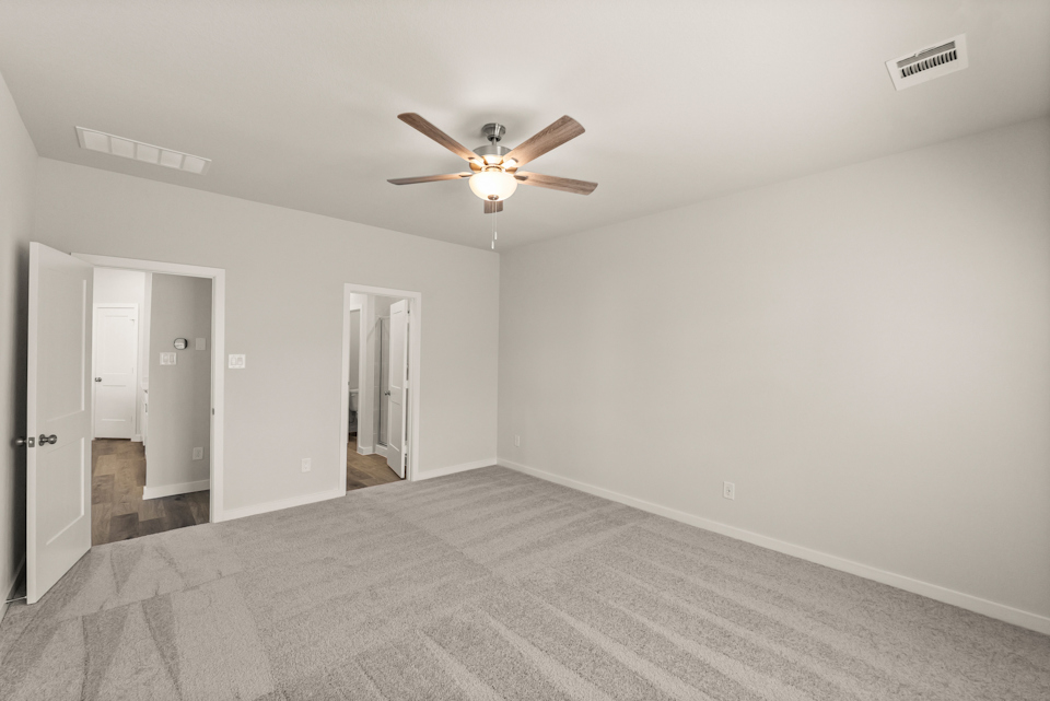 A room with a ceiling fan and a door.