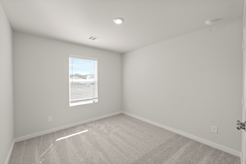 A room with a window and a carpet.