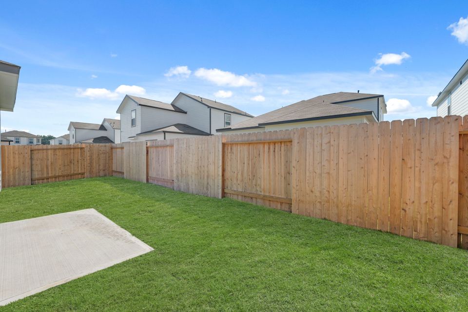 A fenced in yard with a house in the background.