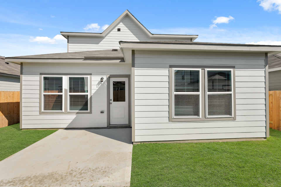 A white house with a green lawn.