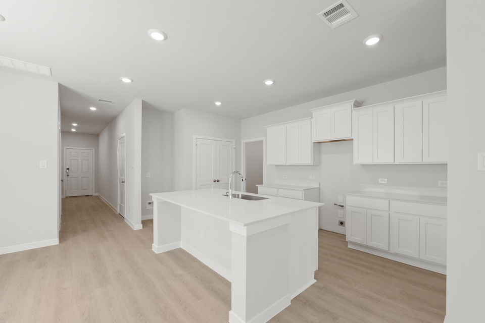 A kitchen with white cabinets.