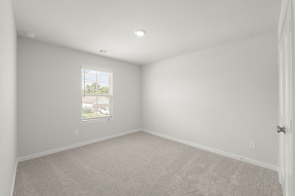 A room with a window and a carpet.