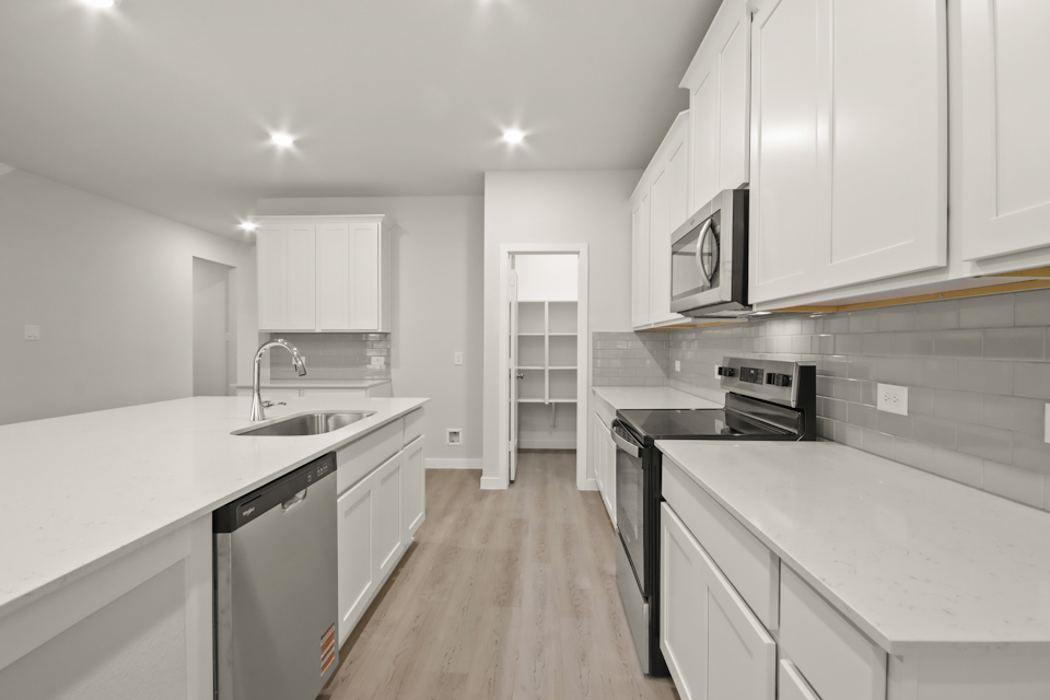 A kitchen with white cabinets.