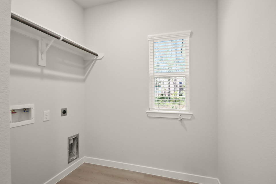 A room with a window and a wood floor.