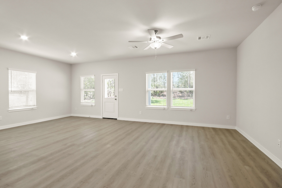 A room with a wood floor and a ceiling fan.