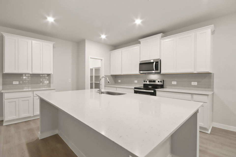 A kitchen with white cabinets.