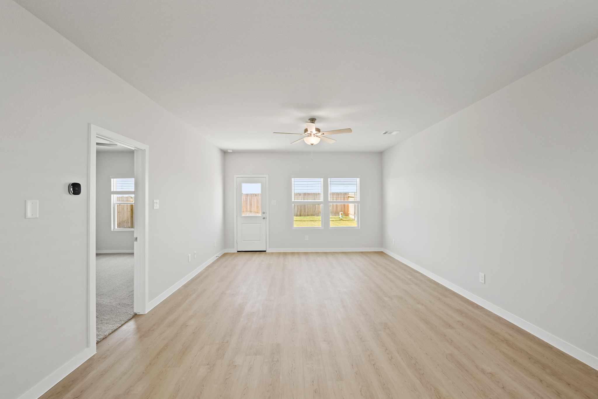 A room with a wood floor and a ceiling fan.