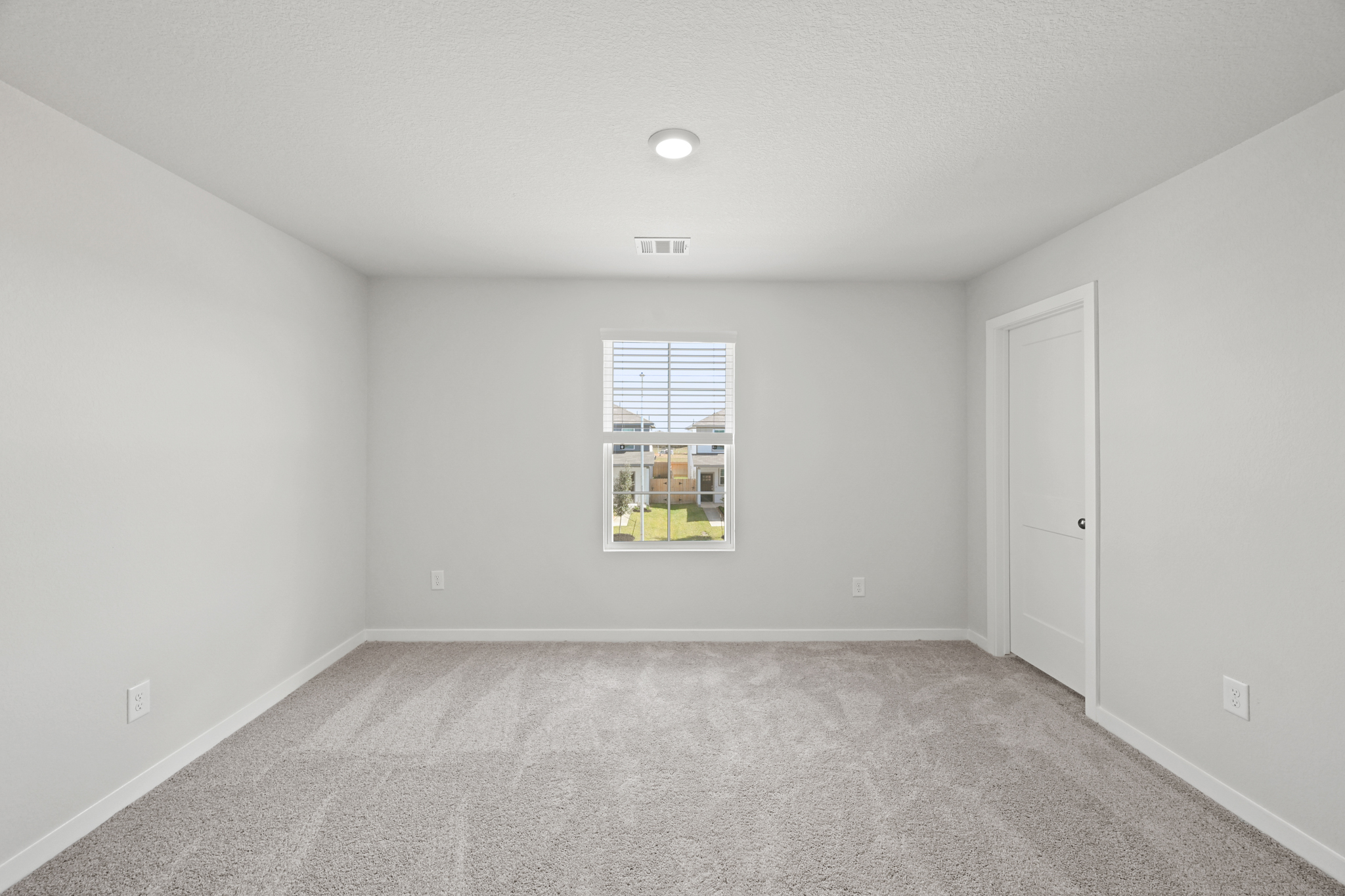 A room with a window and a carpet.