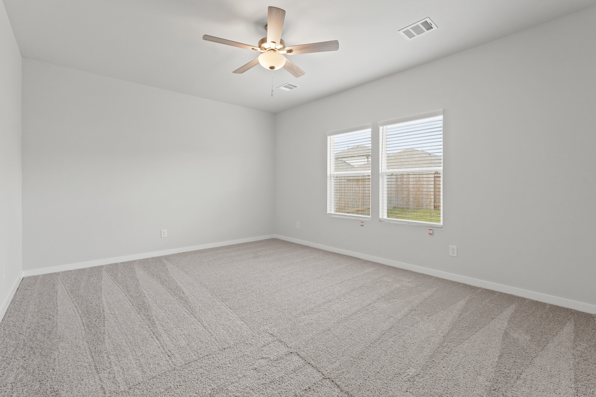 A room with a ceiling fan and a window.