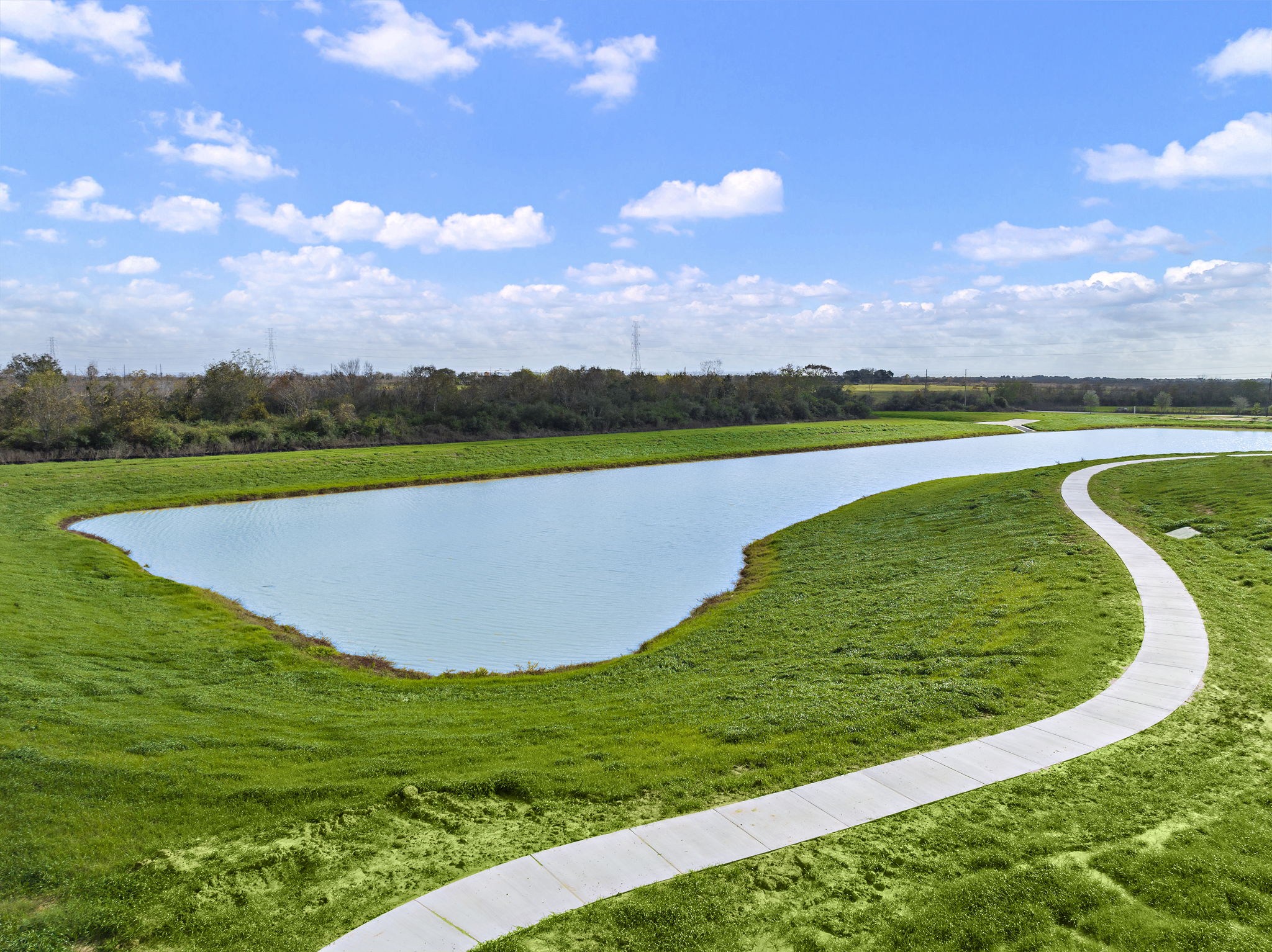 A pond with grass and trees around it.