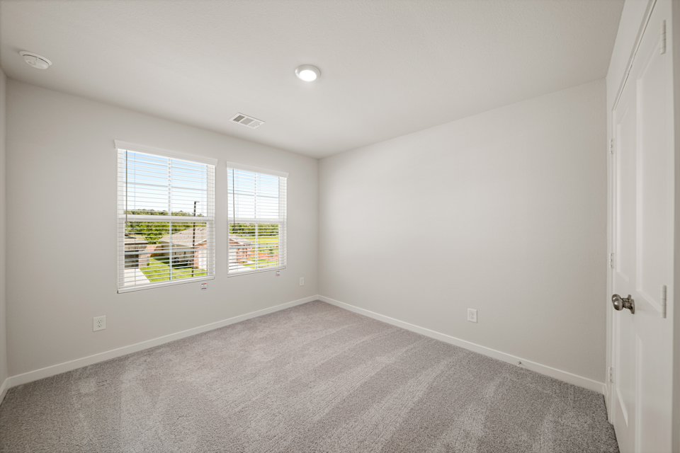 A room with a window and a carpet.