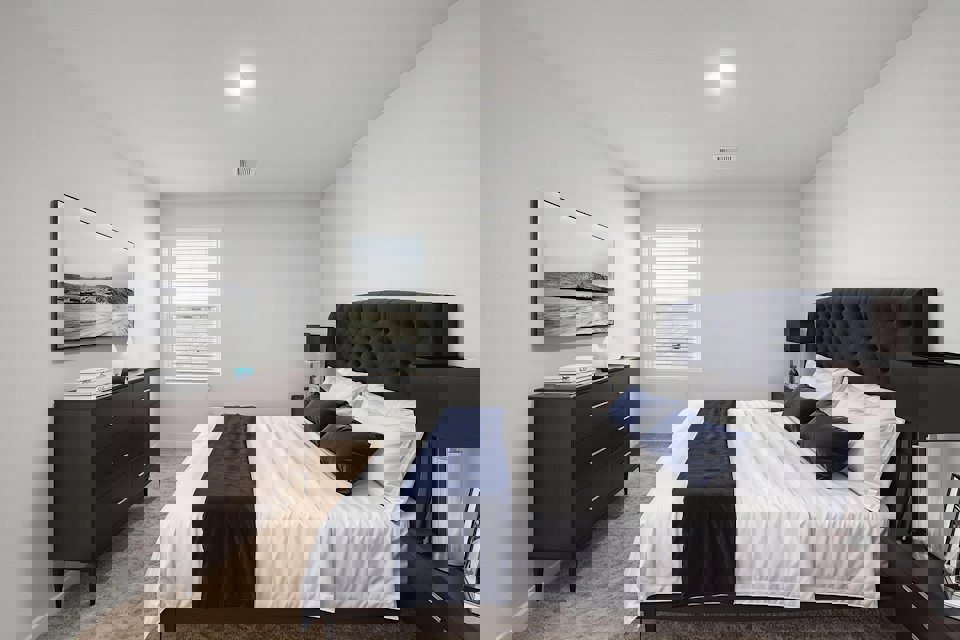 A bedroom with a bed and dresser.