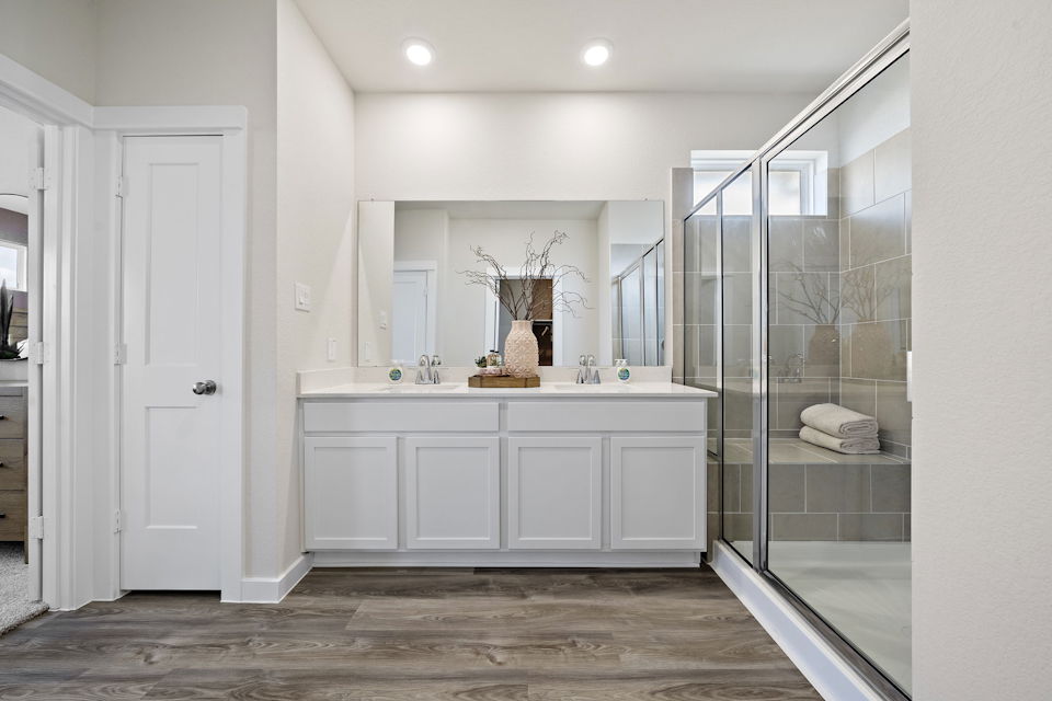 A bathroom with white cabinets.