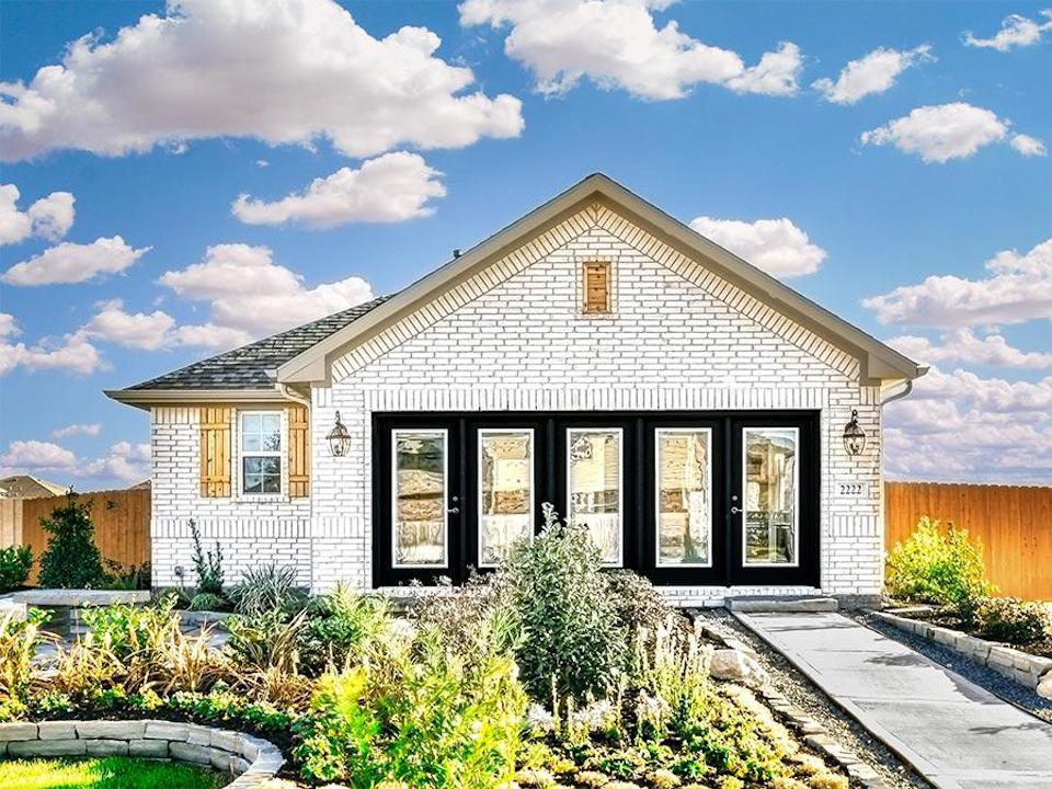 A house with a fence and bushes.