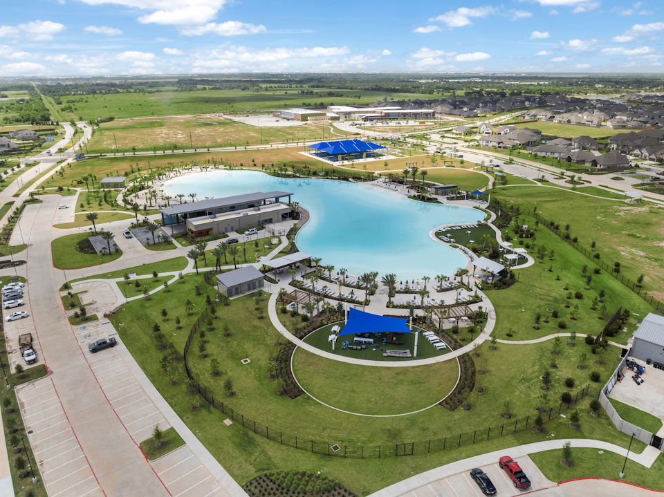 A large building with a pool in the middle of a field.