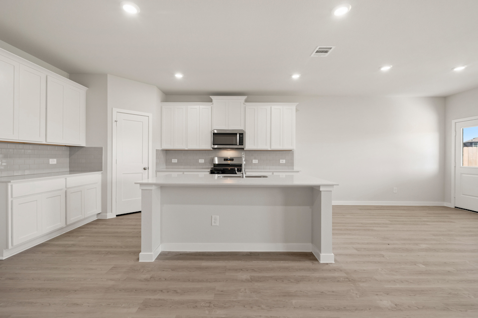 A kitchen with white cabinets.