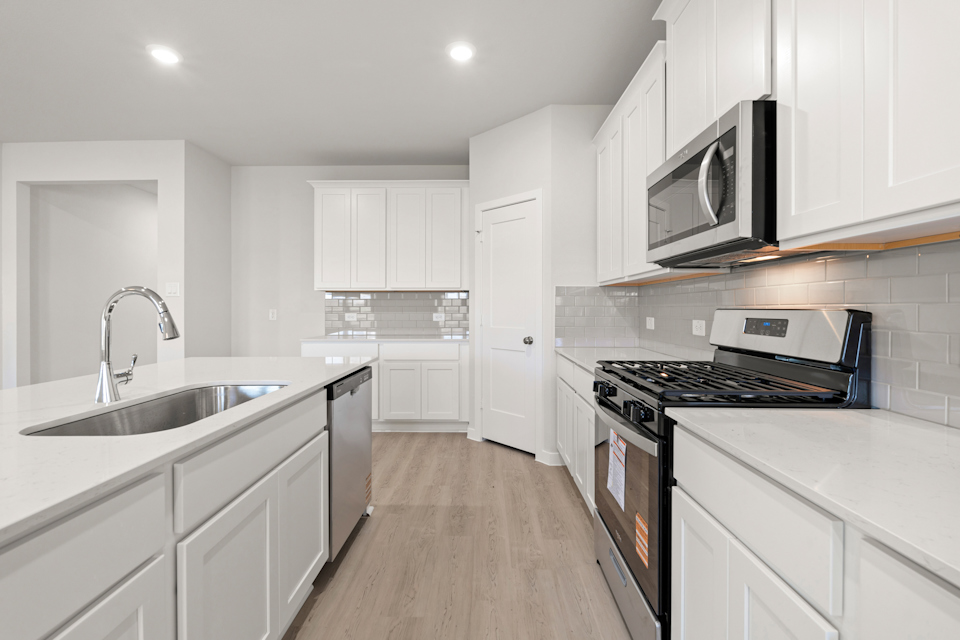 A kitchen with white cabinets.