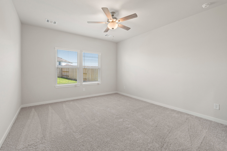 A room with a ceiling fan and a window.