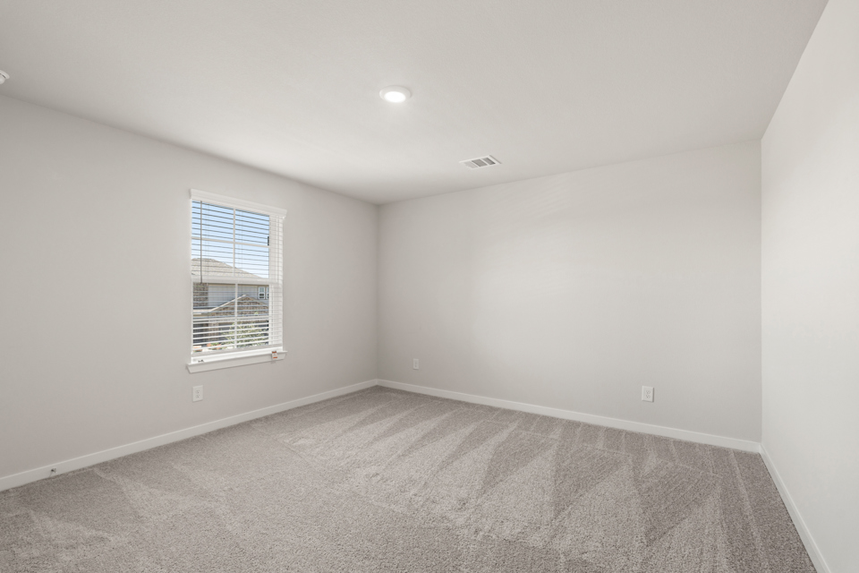 A room with a window and a carpet.