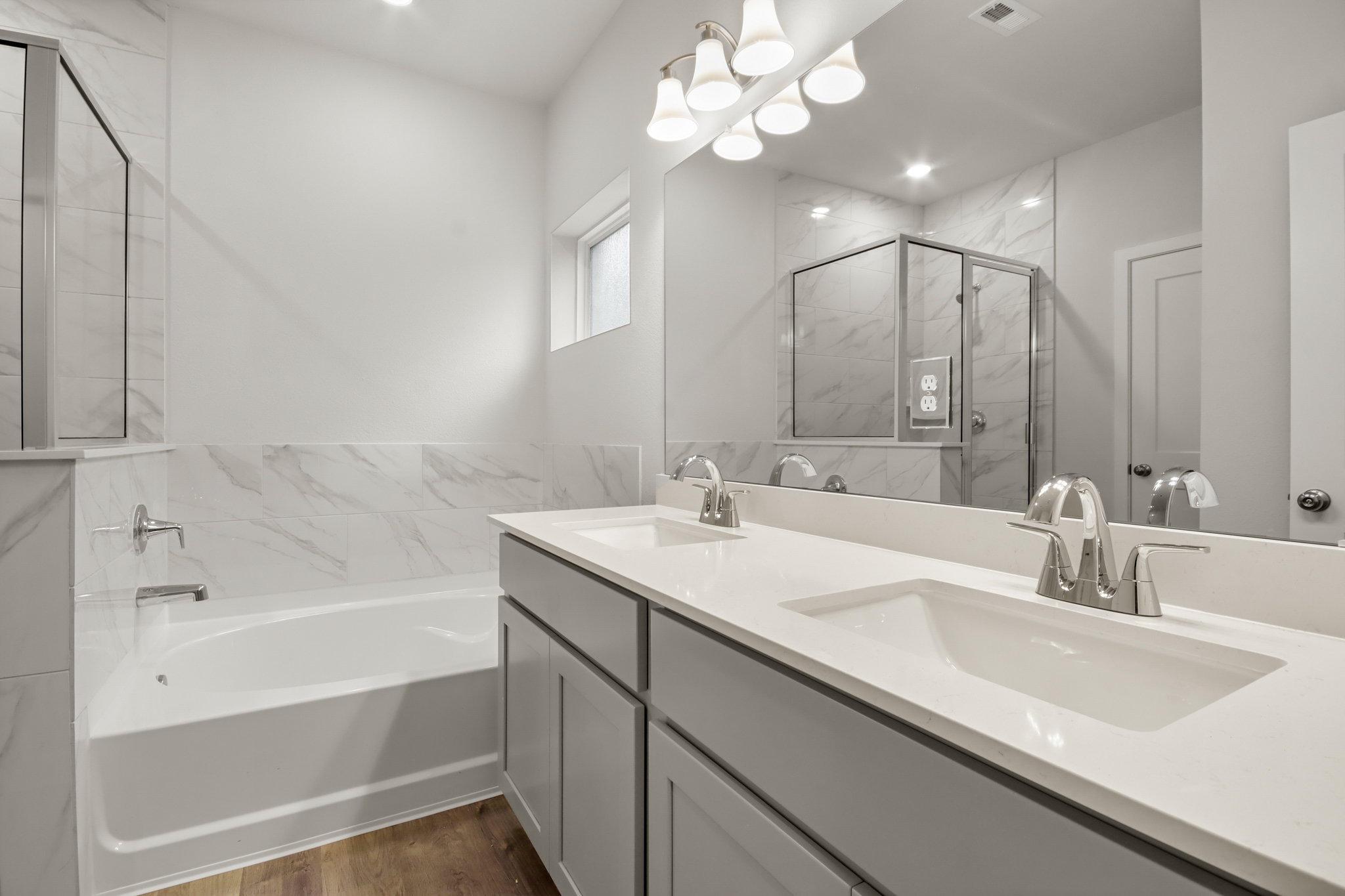 A bathroom with a tub sink and mirror.