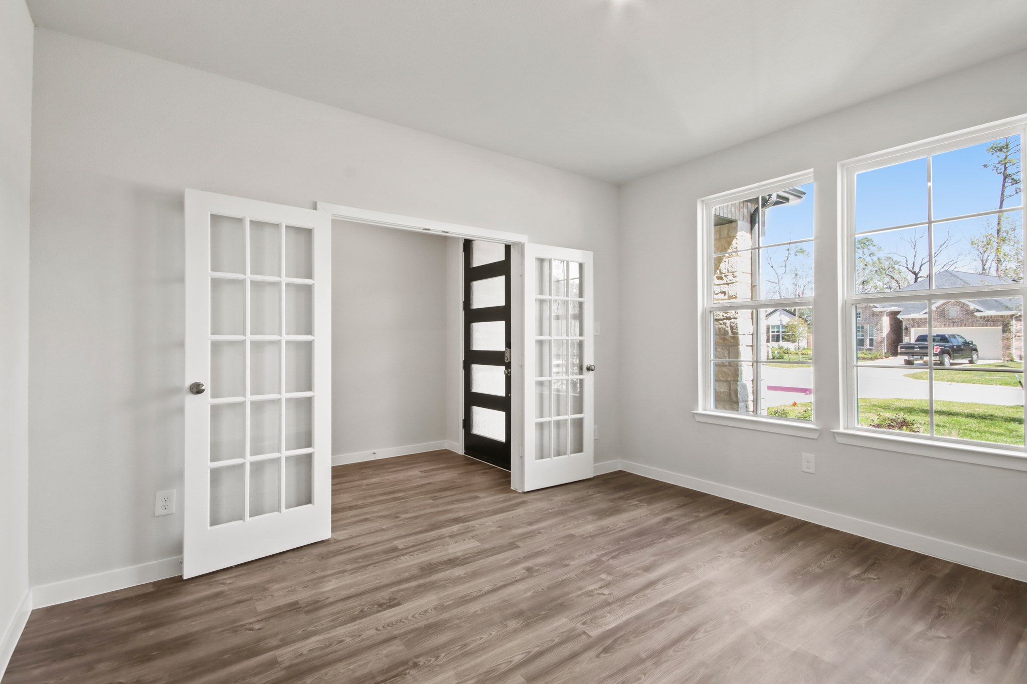 A room with a wood floor and white walls.