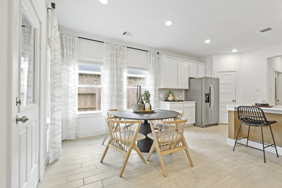 A kitchen with a table and chairs.