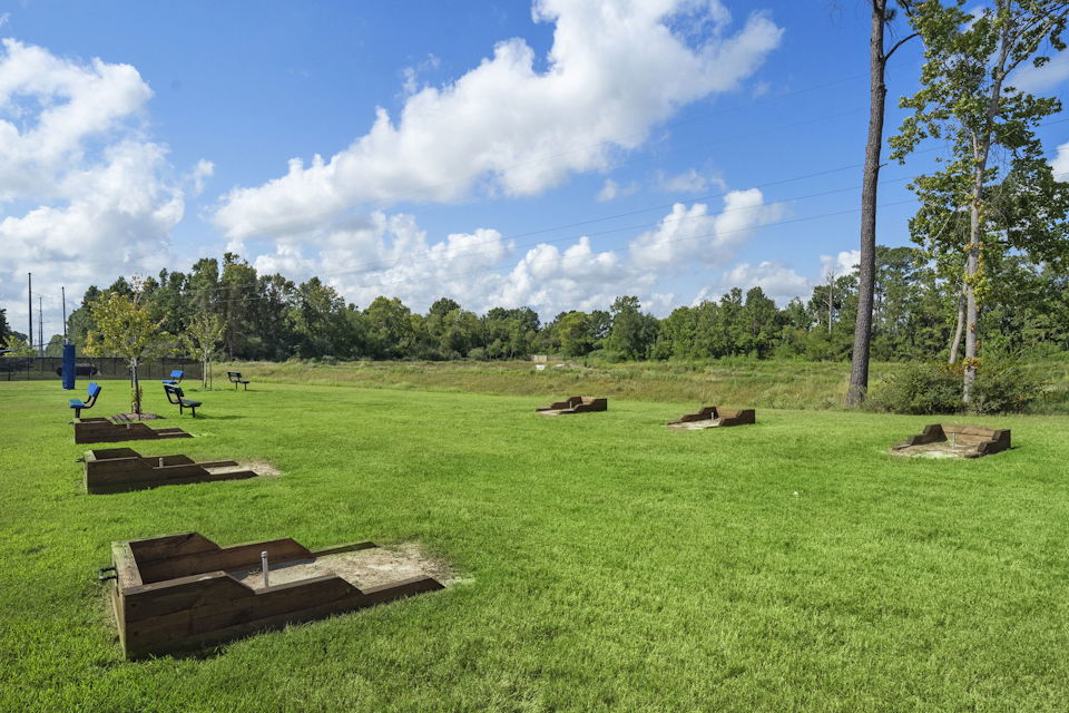 A grassy field with trees in the background.