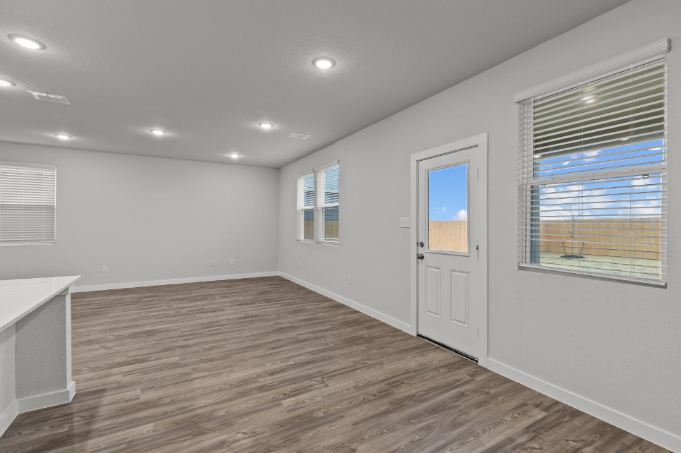 A room with a wood floor and windows.